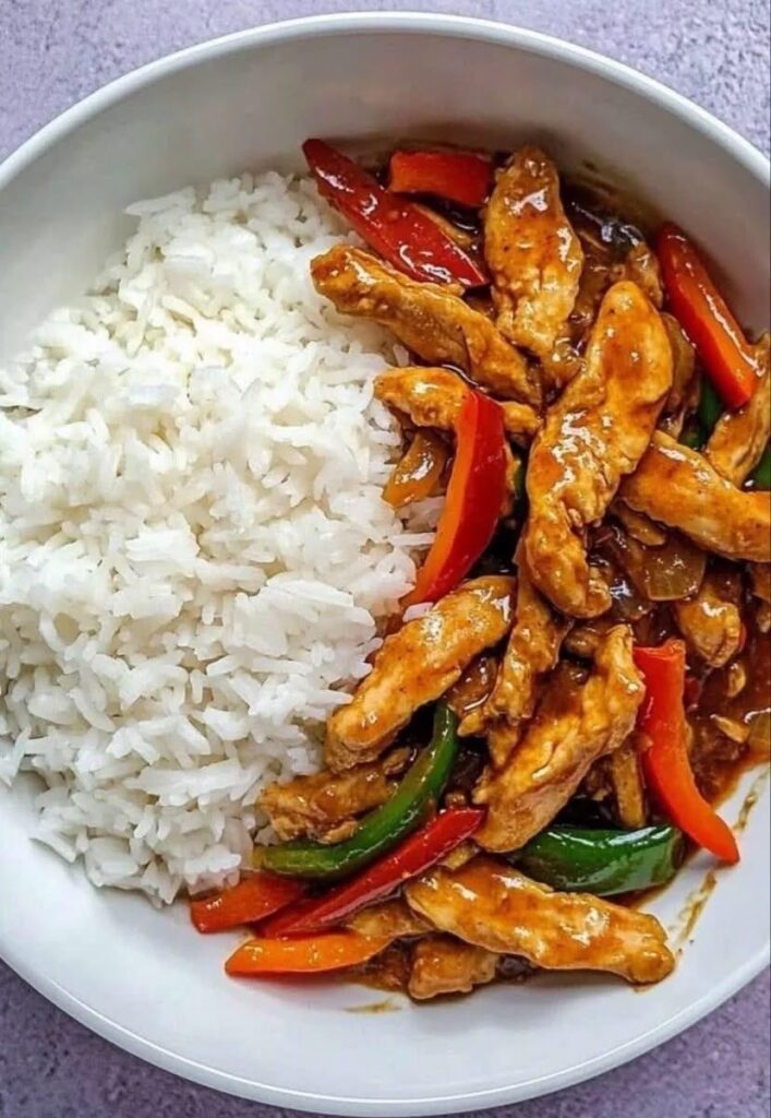 Pui asiatic cu ardei colorați și sos dulce-picant, servit cu orez